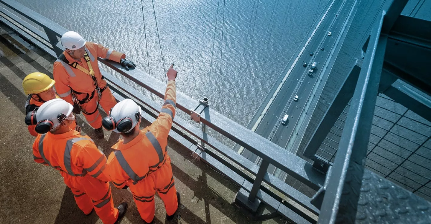 visual of four worker socotec on a bridge